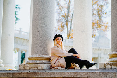 Woman sitting on staircase outside building
