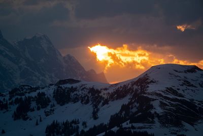 Scenic view of snowcapped mountains against sky during sunset