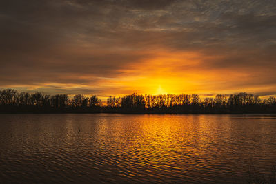 Scenic view of lake against orange sky