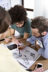 Three colleagues discussing draft in office