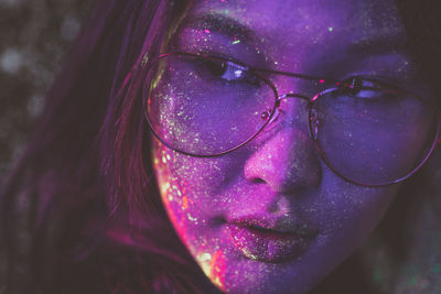 Beautiful young woman with face paint wearing eyeglasses