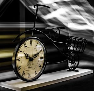 Close-up of clock on table against abstract backgrounds