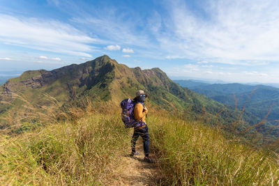 Man standing on mountain against sky