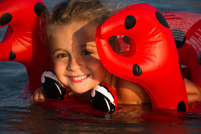 Portrait of cute girl swimming with inflatable ring in sea