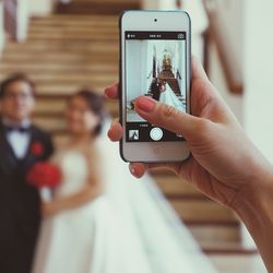 Cropped image of woman photographing through smart phone