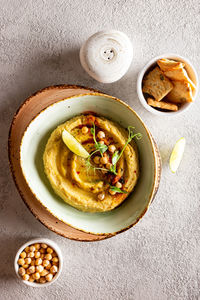 Healthy appetizer classic hummus decorated with greens and spices