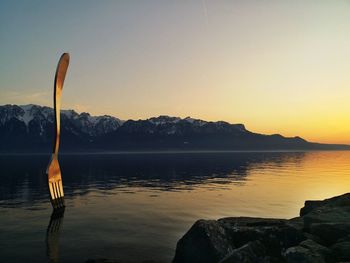 Scenic view of lake against clear sky during sunset