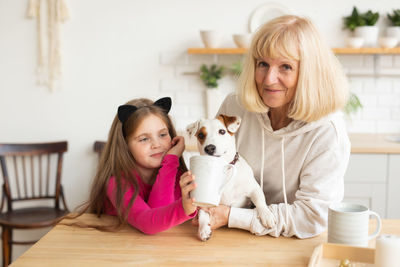 Grandmother with granddaughter sitting with dog