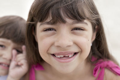 Girl smiling, boy in background