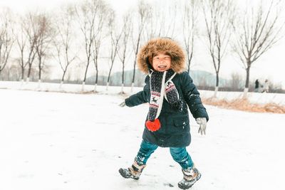 Full length of boy walking on snow covered land