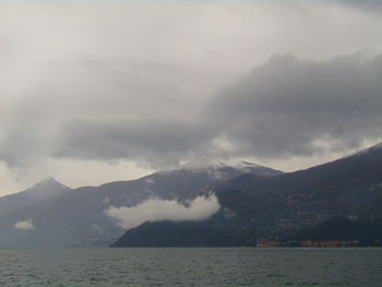 Scenic view of sea and mountains against sky