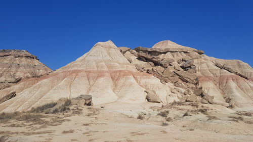 Rock formations in desert against clear blue sky