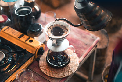 High angle view of coffee pouring in cup on table