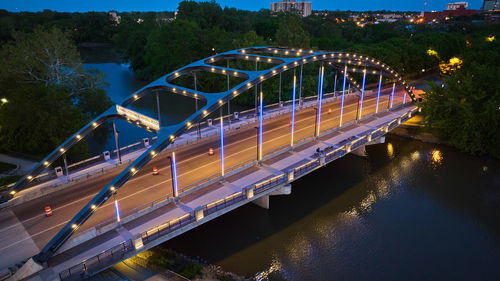 Illuminated bridge over river at night