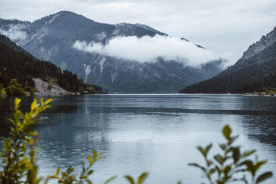 Scenic view of lake by mountains against sky