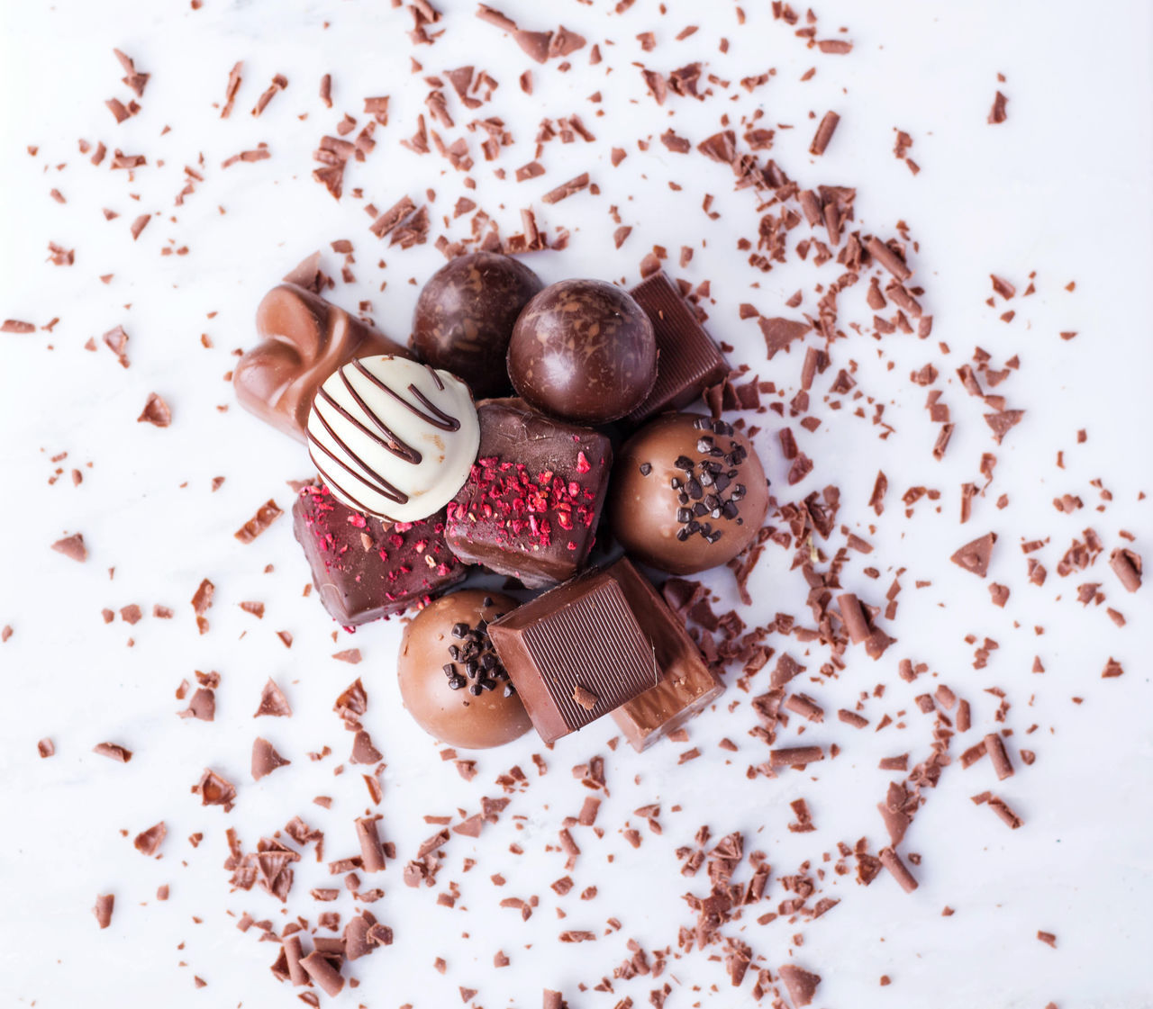 HIGH ANGLE VIEW OF CHRISTMAS ORNAMENTS ON WHITE BACKGROUND