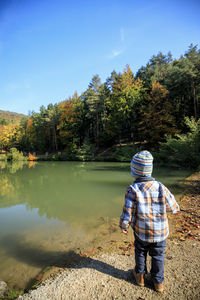 Rear view of man on shore against sky
