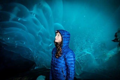 Portrait of woman standing against blue water