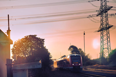 Cars on road against sky during sunset
