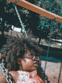 Portrait of a girl on swing at playground