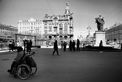 People on street in city against sky