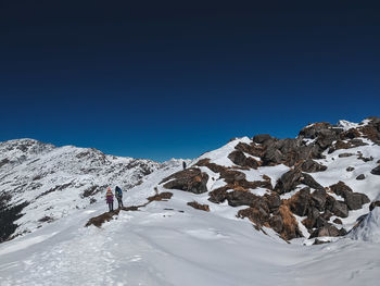 Scenic view of snowcapped mountains against clear blue sky