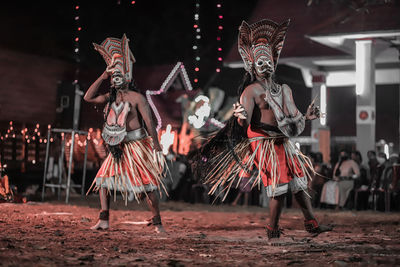 Group of people dancing at night during festival