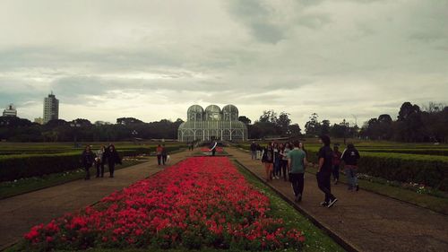 People at town square against cloudy sky