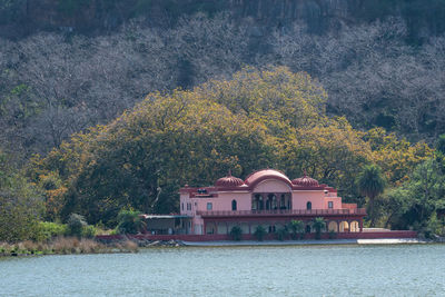 Building by river against trees