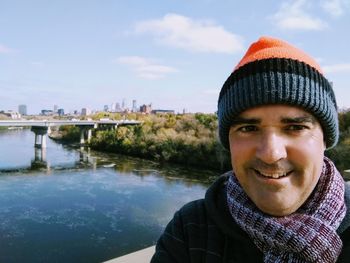 Portrait of smiling man in park against sky during winter