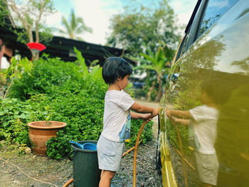 Side view of girl washing car