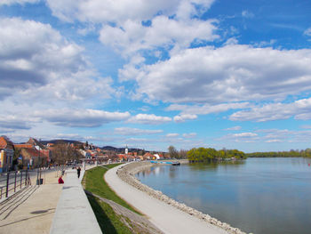 View of tourists on landscape against cloudy sky