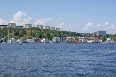 Scenic view of sea by buildings against sky