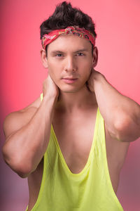 Portrait of handsome male model posing against coral background