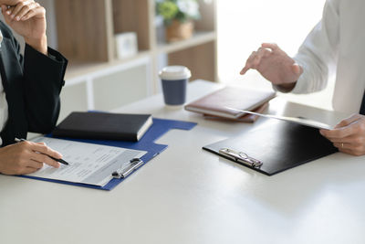 Midsection of man using mobile phone on table