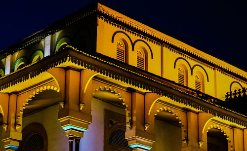 Low angle view of illuminated building against sky at night