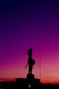 Silhouette statue against sky during sunset