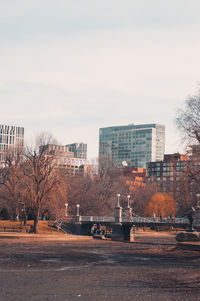 Empty pond and buildings in city against sky