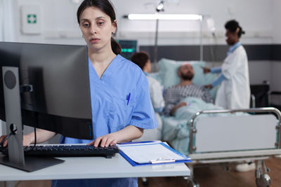 Female nurse working on desktop pc at hospital