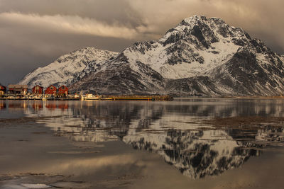 Scenic view of lake by mountains against sky