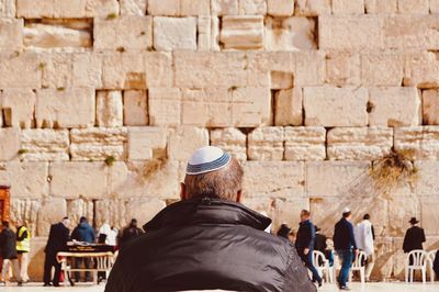 Rear view of people against wall