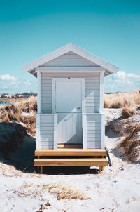Wooden hut at skanör beach against clear blue sky.