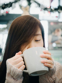 Close-up of woman drinking coffee in cup