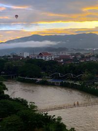 High angle view of river and buildings against sky at sunset