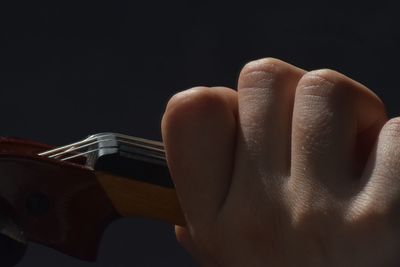 Close-up of person hand against black background