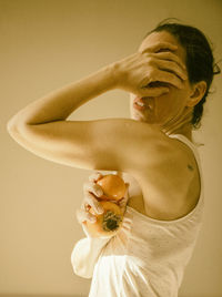 Woman with a persimmon and a tangerine in her hand