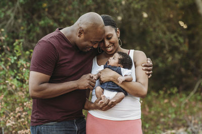 Close up happy mother and father cuddling newborn girl