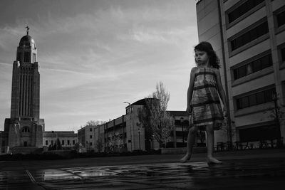 Girl standing against nebraska state capitol building 