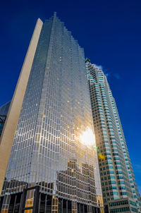 Low angle view of modern buildings against clear blue sky