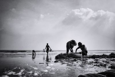 People on beach against sky